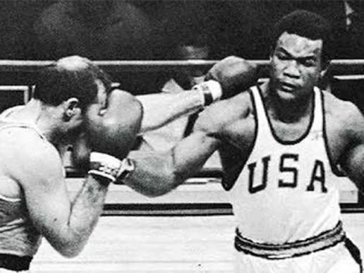 George Foreman *bên phải* - nhà vô địch hạng nặng bất bại với những cú đấm như búa bổ